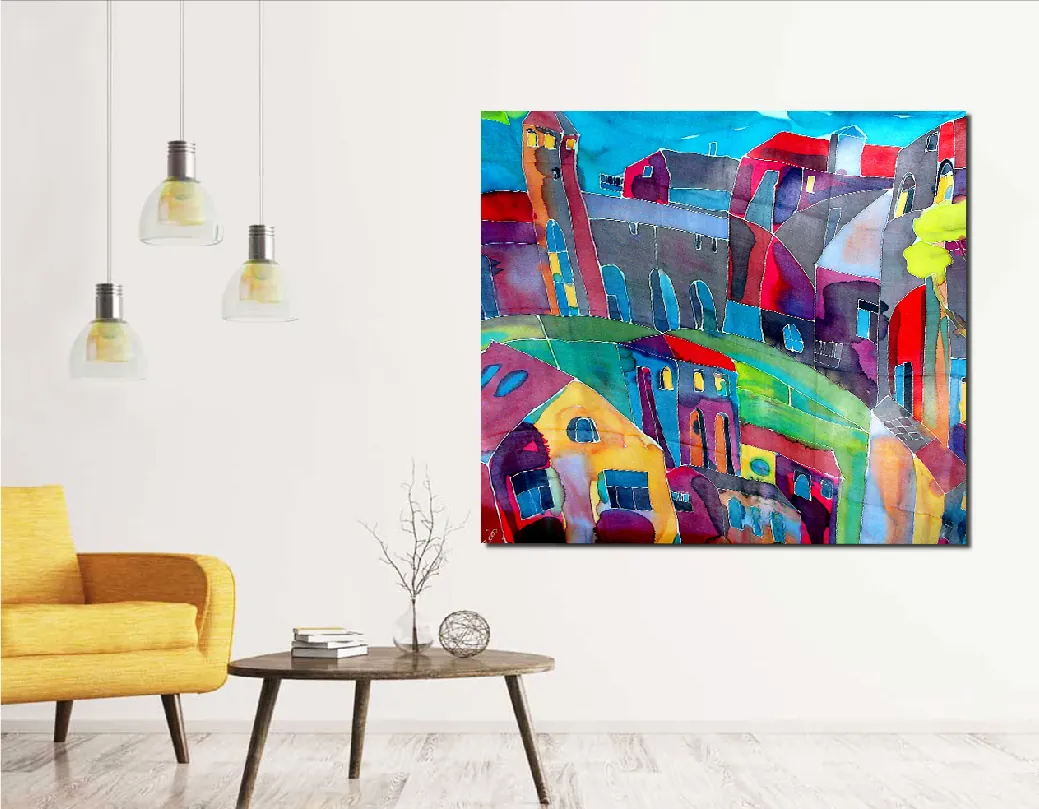 A colorful painting of crowded rooftops, towers and arched windows in blue, magenta, yellow and green, hanging above a low table beside a yellow armchair.